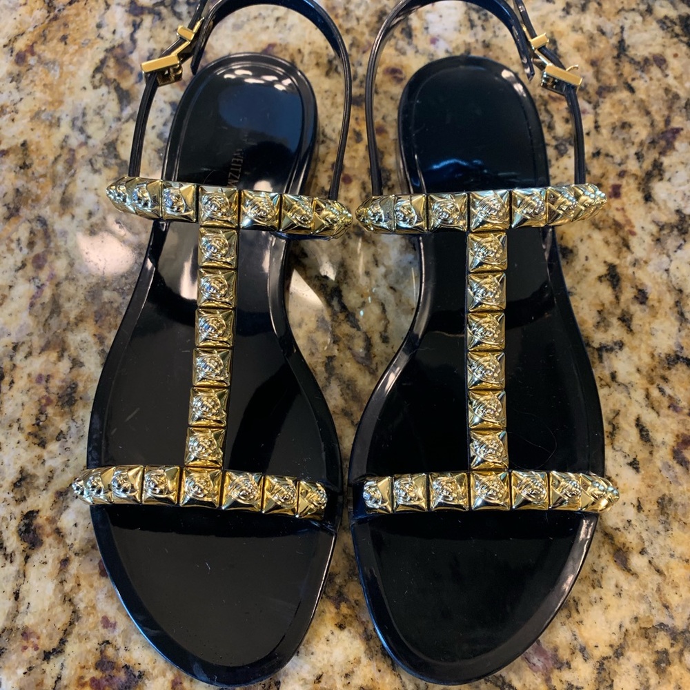 Stewart Weizmann black and gold jelly sandals.